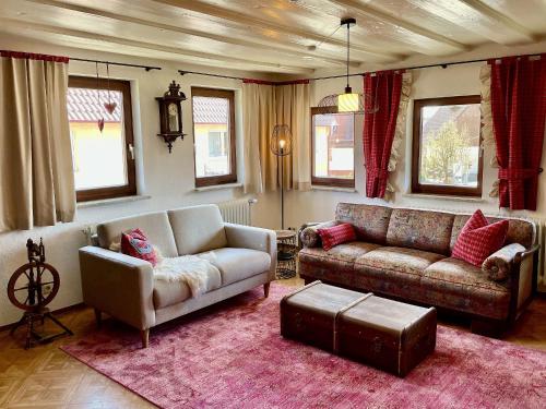 a living room with two couches and a rug at Ferienwohnungen im Eugenhaus in Rosenfeld