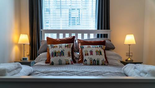 a bedroom with a bed with pillows and a window at The Old Paint Shop Apartment - Centrally Situated in Anstruther