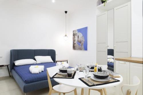 un soggiorno con un tavolo e un divano blu di ELORO - Guest Houses a Noto