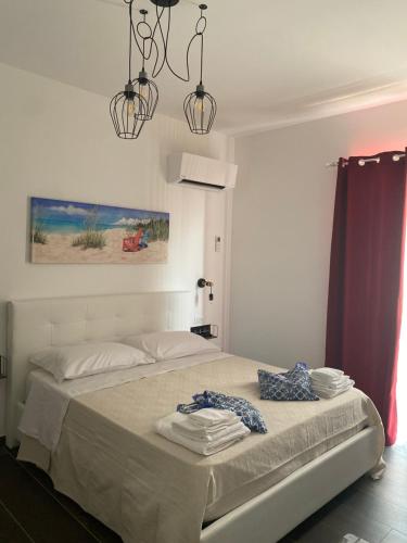 una camera da letto con un letto e asciugamani di B&B Libertà a Pachino