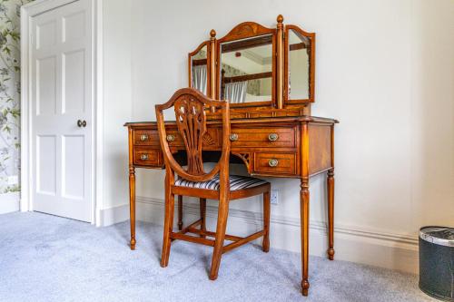 a wooden desk with a mirror and a chair at Leigh Park Country House Hotel & Vineyard, BW Signature Collection in Bradford on Avon
