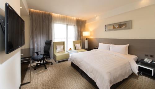 a hotel room with a bed and a television at Forte Hotel Changhua in Changhua City