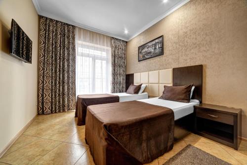 Hotel Marton Rokossovskogo في فولغوغراد: غرفة فندقية بسريرين ونافذة