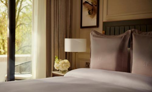 a bed with a white comforter and pillows at The Carlton Tower Jumeirah in London