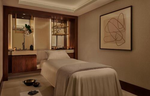 a bedroom with a bed and a bathroom with a sink at Jumeirah Carlton Tower London in London
