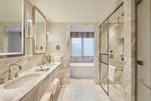 a bathroom with two sinks and a shower at Jumeirah Carlton Tower London in London