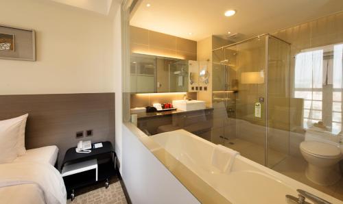 彰化市的住宿－彰化福泰商務飯店，带浴缸、床和淋浴的浴室