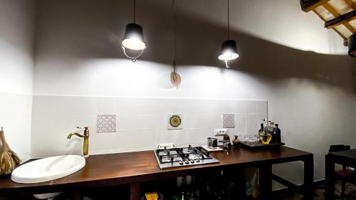 a kitchen with a counter and a stove and lights at Arte Povera Landhaus in idyllischem Naturreservat in Custonaci