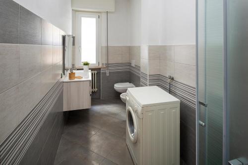 a bathroom with a toilet and a washing machine at Appartamenti Villa Miramare in Rimini