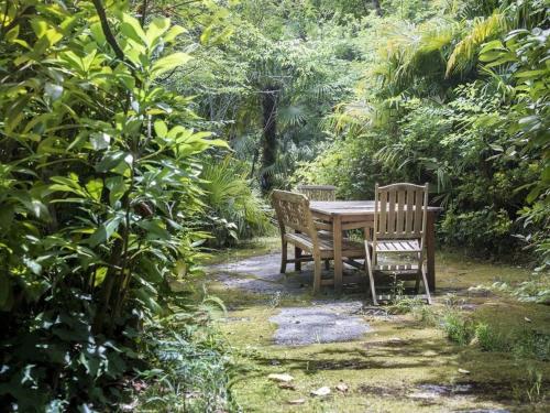 a wooden table and two chairs in a garden at Oasis in Arcachon