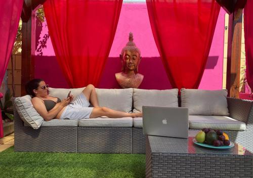 a woman sitting on a couch in front of a statue at Casa Concha - Peaceful and Relaxing in Lagos