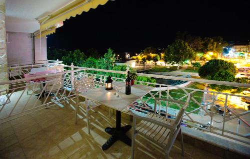 a table and chairs on a balcony at night at Hotel Epavli in Nea Kalikratia