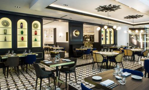 a restaurant with tables and chairs in a room at Sofitel Lisbon Liberdade in Lisbon