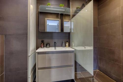 a bathroom with a sink and a mirror and a shower at Proche Paris - Suite Cosy - Wifi, Netflix in Chatou