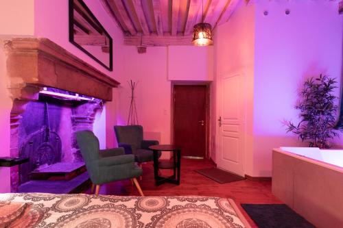 d'un salon avec une cheminée et un éclairage violet. dans l'établissement Luxury Spa, à Dijon