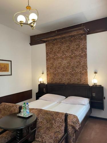 a bedroom with a large bed and a table at Hotel Dwór Polski in Wrocław