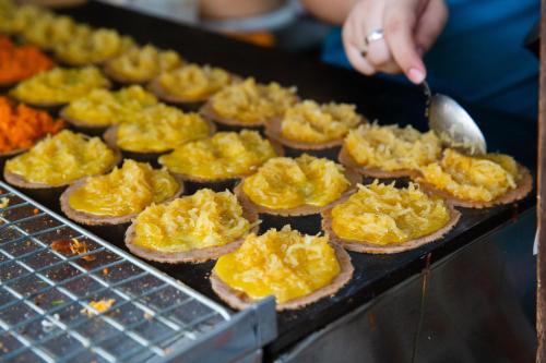 a person is cooking food on a grill at Nappiness Hotel - SHA ExtraPlus in Bangkok