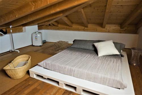 Cama grande en habitación con techo de madera en La casa di Claudia, en Arco
