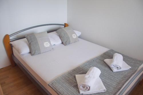 a small bed with two pillows and towels on it at Apartment Noel in Novalja
