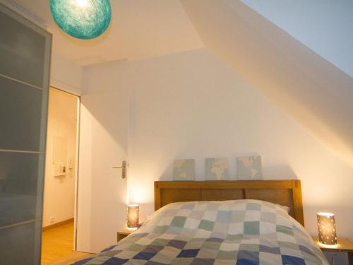 a bedroom with a bed with a blue and white comforter at StudioLille - Alexandre in Lille