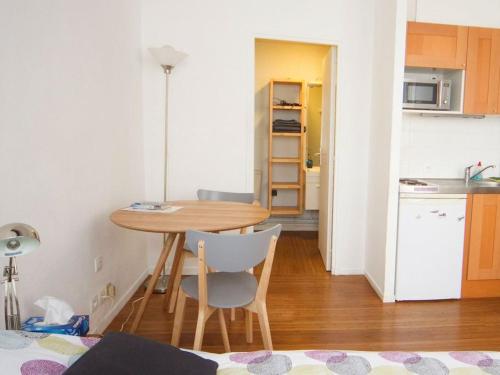 una pequeña cocina con mesa y sillas en una habitación en StudioLille - Opéra, en Lille