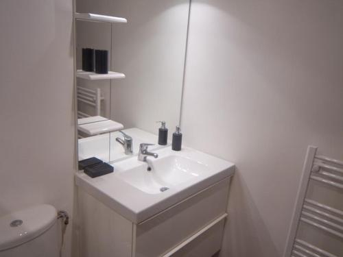 a white bathroom with a sink and a toilet at StudioLille - Beaux-Arts in Lille