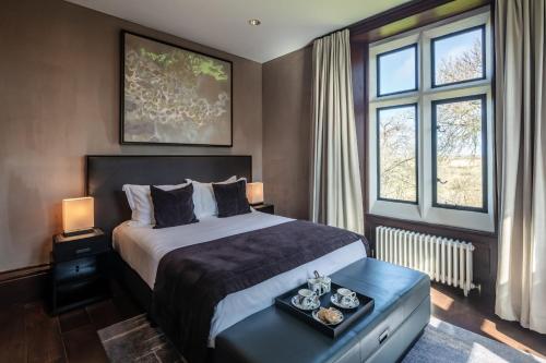 a hotel room with a bed and two windows at Penrhiw Priory in St. Davids
