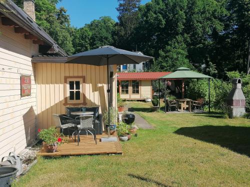 einen Hinterhof mit einem Tisch und einem Sonnenschirm in der Unterkunft Villa Irbe in Jūrmala
