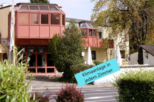 a sign in front of a hotel with a building at Mariaweiler Hof in Düren - Eifel