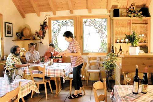 a woman standing at a table in a restaurant at Weingut Rosenbaum in Briedel