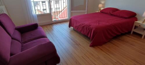 a bedroom with a purple bed and a couch at Appartement 83 m2, 4 lits , 5 Pers, 100 m de la gare, Confortable et Lumineux in Le Havre