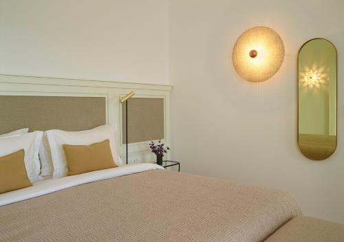 a bedroom with a large bed and a mirror at Bonzoe Suites & Villas in Mýkonos City