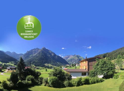 a house in a field with mountains in the background at Ahorn Chalet Mittelberg in Mittelberg