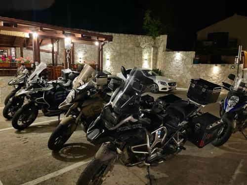 a row of motorcycles parked in a parking lot at night at Hotel Galia in Kotor