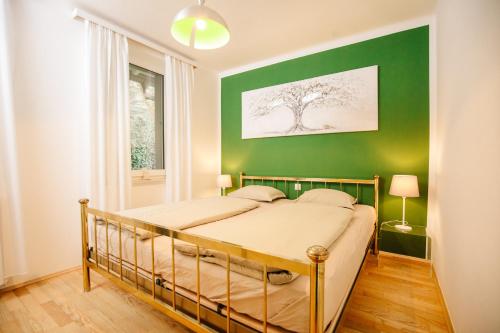 a bedroom with a green wall and a bed at Velden - Villa right in the center with private parking in Velden am Wörthersee