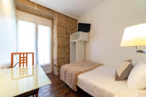 a bedroom with a bed and a glass table at Pension Aida in Donostia-San Sebastián