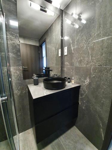 a bathroom with a black sink and a shower at Positano Apartman in Sárvár