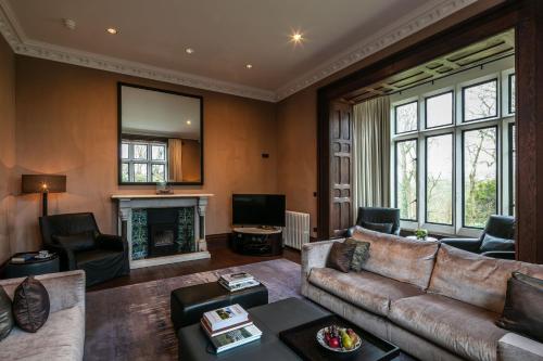 a living room with a couch and a fireplace at Penrhiw Priory in St. Davids
