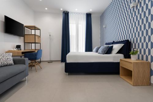 um quarto com uma cama, um sofá e uma mesa em HSuites Luxury B&B em Castellammare di Stabia