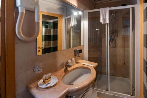 a bathroom with a sink and a shower at San Simeon Apartments in Venice