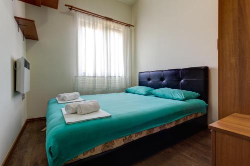 ein Schlafzimmer mit einem Bett mit zwei Handtüchern darauf in der Unterkunft Apartments LungoMare in Tivat