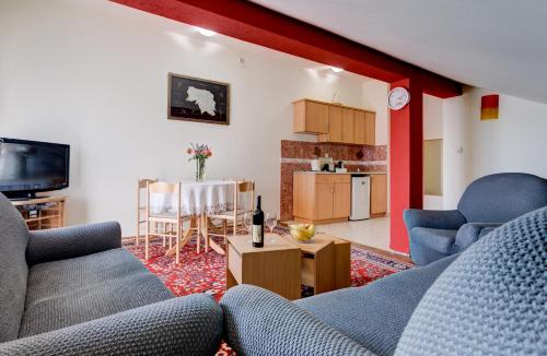 ein Wohnzimmer mit 2 Sofas und einer Küche in der Unterkunft Apartments LungoMare in Tivat