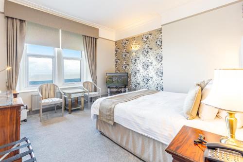 a hotel room with a bed and a desk and a television at Best Western Walton Park Hotel in Clevedon