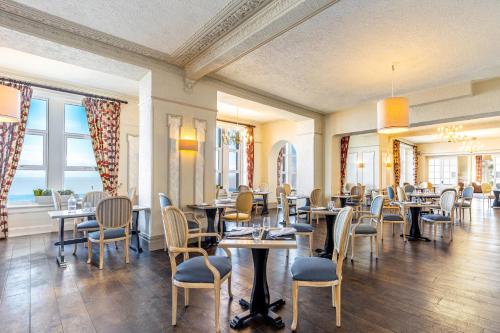 uma sala de jantar com mesas, cadeiras e janelas em Best Western Walton Park Hotel em Clevedon