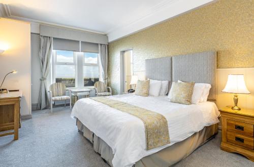 a large bedroom with a large bed and a desk at Best Western Walton Park Hotel in Clevedon