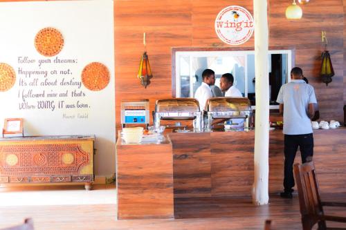 two men standing at the counter of a restaurant at Kikoi Boutique Hotel in Michamvi