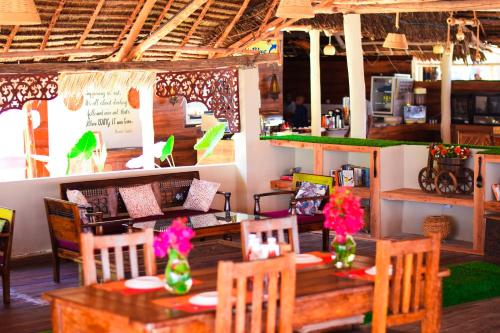a restaurant with a table and chairs with flowers on it at Kikoi Boutique Hotel in Michamvi