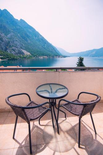 a table and chairs on a balcony with a view of a lake at Gemma di Cattaro Apartments in Kotor