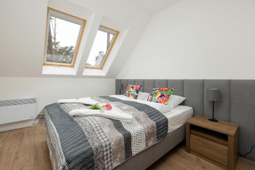 1 dormitorio con 1 cama y 2 ventanas en Apartamenty Zielona 11 by Renters, en Międzywodzie