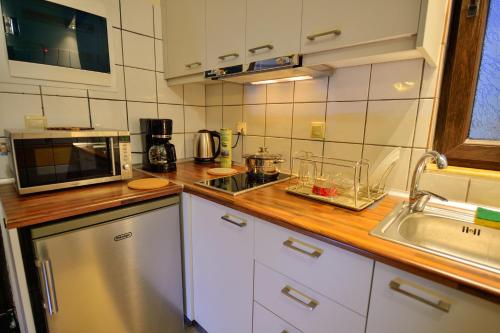 a kitchen with a counter with a sink and a microwave at Balcony Rooms in Elafonisi